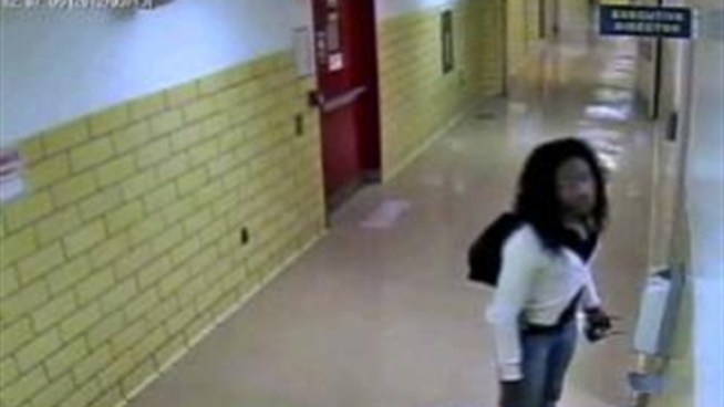 Police say the suspect seen in this surveillance video is a man dressed as a woman and has been impersonating a police officer to rob a victim and to gain access to a hospital's administrative offices.