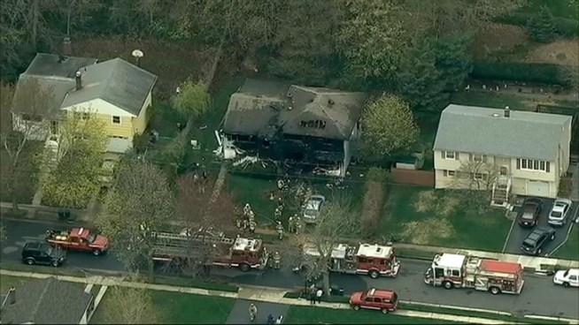 Firefighters sift through wreckage after an early morning fire kills four people in southern New Jersey.