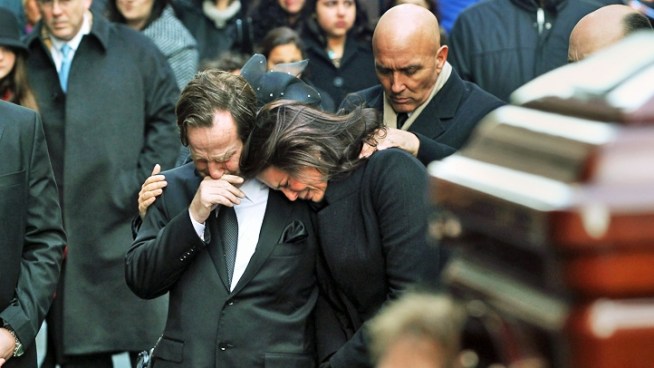 The parents of the three girls who died with their grandparents during a Christmas morning fire in Stamford, Conn., struggle with grief as they watch their daughters' caskets being carried into the church for their funeral.