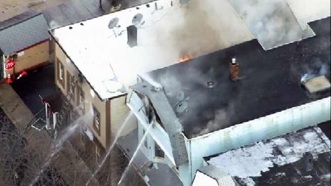 Firefighters are on the scene of a fast-moving fire that's engulfed one home and threatening to spread to neighboring houses in Bayonne, N.J.