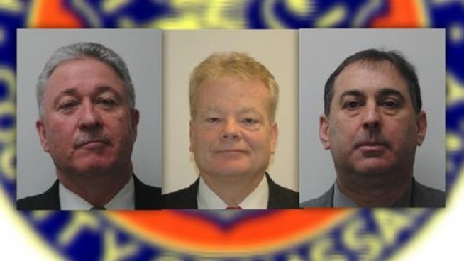 A former deputy commissioner and two other top Nassau County police officials surrendered Thursday to face allegations they pulled strings to drop a 2009 burglary investigation against the son of a wealthy department benefactor, prosecutors said.