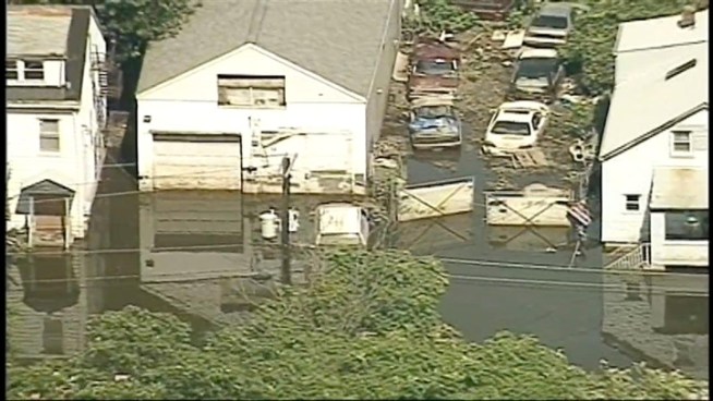 The Passaic River is receding, but flood waters continue to envelop homes and cars throughout Paterson, N.J., where President Barack Obama is scheduled to visit Sunday.