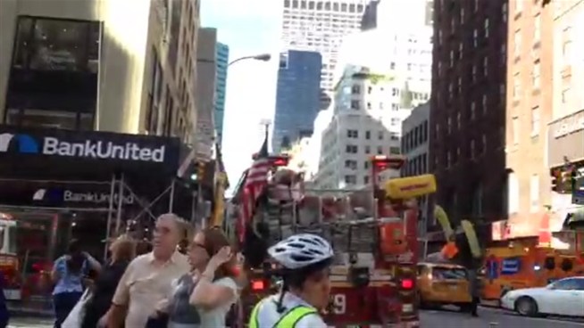 Authorities rescued men trapped on scaffolding that apparently became unhinged on one side as they were working in midtown Friday morning, fire officials say. NBC 4 New York obtained cell phone video of the dangling scaffolding.