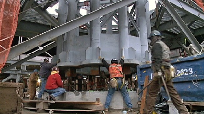Workers using two giant cranes on the 104th floor roof of One World Trade Center installed the first piece of the spire that will make it the tallest building in the Western Hemisphere.