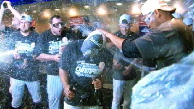 The Yankees celebrate their AL East title with champagne in the locker room.
