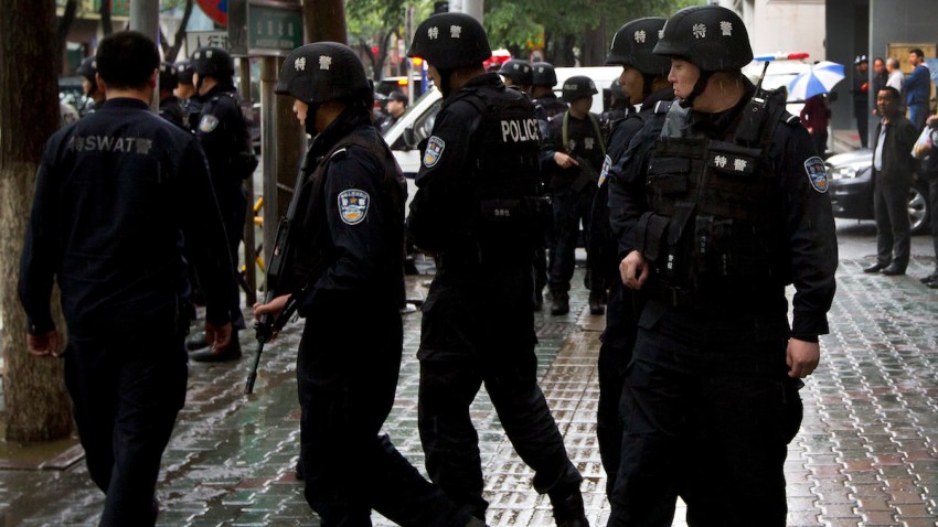 In this May 22, 2014 photo, armed policemen prepare to patrol near the site of an explosion in Urumqi, northwest China's Xinjiang Uygur Autonomous Region.