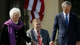 From left, former first lady Barbara Bush, President George H.W. Bush and former president George W. Bush hold hands during the invocation during the dedication of the George W. Bush Presidential Center Thursday, April 25, 2013, in Dallas. (AP Photo/David J. Phillip)