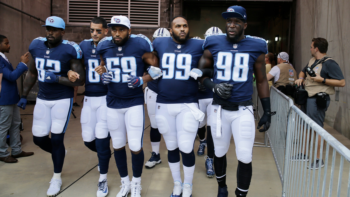 Tennessee Titans players walk to the field with arms linked after the national anthem had been played before an NFL football game between the Titans and the Seattle Seahawks Sunday, Sept. 24, 2017, in Nashville, Tennessee. Neither team stood on the field for the anthem. From left are Delanie Walker (82), Marcus Mariota (8), Wesley Woodyard (59), Jurrell Casey (99) and Brian Orakpo (98).