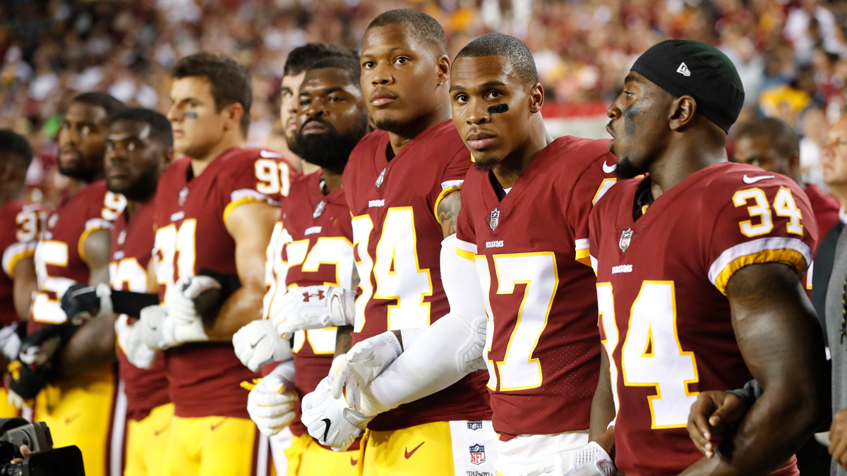 Member of the Washington Redskins stand arm-in-arm during the playing of the national anthem before an NFL football game against the Oakland Raiders in Landover, Maryland, Sunday, Sept. 24, 2017.