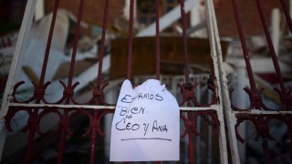 A note that reads "We're well. Ceo and Ana," hangs on a fence