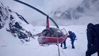 In this Saturday, Jan. 18, 2020 photo, trekkers are being rescued in a helicopter a day after an avalanche hit Mount Annapurna trail in Nepal. Special army and government rescue personnel were searching again on Monday for four South Korean trekkers and their three Nepali guides lost since an avalanche swept a popular trekking route in Nepal’s mountains.