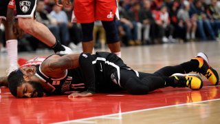 Brooklyn Nets guard Kyrie Irving lies on the court after injury