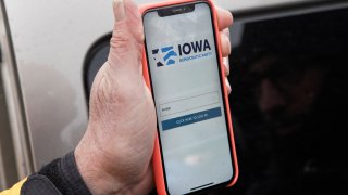 Precinct captain Carl Voss of Des Moines displays the Iowa Democratic Party caucus reporting app on his phone outside of the Iowa Democratic Party headquarters in Des Moines, Iowa, Feb. 4, 2020. Technical difficulties with the app delayed expected results the night of the Iowa caucus, forcing the Democratic National Committee to release results intermittently throughout the week.
