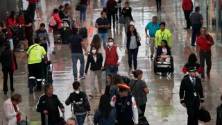 A couple wears protective masks as a precaution against the spread of the new coronavirus at the airport in Mexico City, Friday, Feb. 28, 2020.