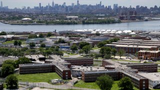 FILE – In a June 20, 2014, file photo, the Rikers Island jail complex stands in New York with the Manhattan skyline in the background. The nation’s jails and prisons are on high alert about the prospect of the new coronavirus spreading through their vast inmate populations. (AP Photo/Seth Wenig, File)