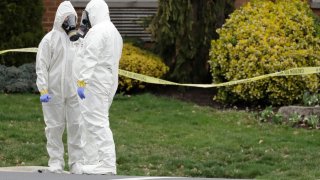 Emergency personnel in protective suits help move people out of St. Joseph's Senior Home in Woodbridge, N.J., Wednesday, March 25, 2020.