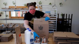 Monica Mileur packs grocery items into a box