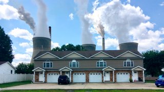 FILE - In this Aug. 23, 2018, file photo, a coal-fired plant in Winfield, W.Va, is seen from an apartment complex in the town of Poca across the Kanawha River.