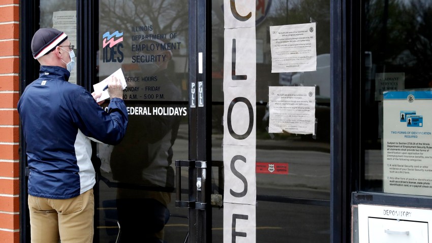 In this April 30, 2020 file photo, a man writes information in front of Illinois Department of Employment Security in Chicago. U.S. businesses cut an unprecedented 20.2 million jobs in April, an epic collapse with coronavirus outbreak closing the offices, factories, schools, construction sites and stores that propel the U.S. economy. The Wednesday, May 6, report from payroll company ADP showed the tragic depth and scale of job losses that left no part of the world’s largest economy unscathed.