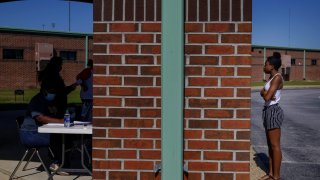 In this Thursday, May 7, 2020 photo, Azandria Torbert, stands in line for graduation information at Chattahoochee County High School after the school district called an early end to the school year, in Cusseta, Ga.