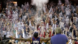 In this Dec. 25, 2008, file photo, fans toss confetti to mimic Cleveland Cavaliers' LeBron James's pre-game chalk toss before an NBA basketball game against the Washington Wizards in Cleveland. Billions has been spent on state-of-the-art sports facilities over the last quarter-century, but there is no way to prevent the potential spread of a virus through coughing or sneezing. Officials are working on safety protocols and looking at new technology in hopes of making stadiums and arenas as safe as they can.