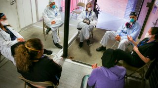 Hospital workers sit for a group counseling session at Elmhurst Hospital to talk about their experiences dealing with the COVID-19 pandemic, Friday, May 29, 2020, in New York.