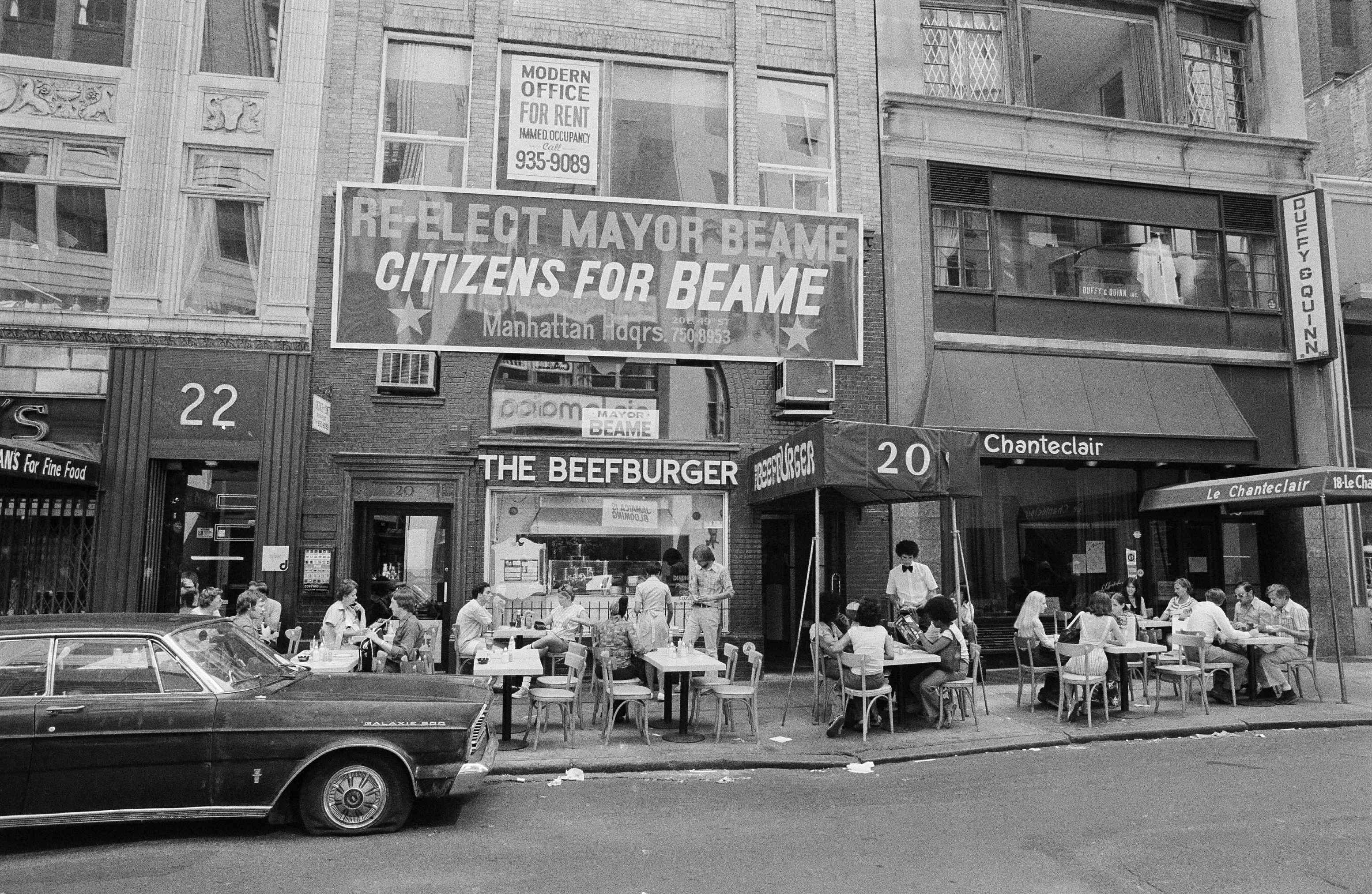 A midtown, Manhattan restaurant moved its tables and customers to the sidewalk, July 14, 1977, after a massive power failure in New York City cut off electricity inside. (AP Photo/Marty Lederhandler)