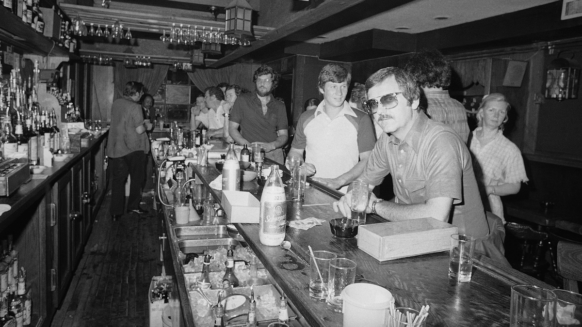 People in a mid-town Manhattan bar keep drinking by candlelight in New York on Wednesday, July 13, 1977 after the city was struck by a power failure. (AP Photo/Steve Oualline)