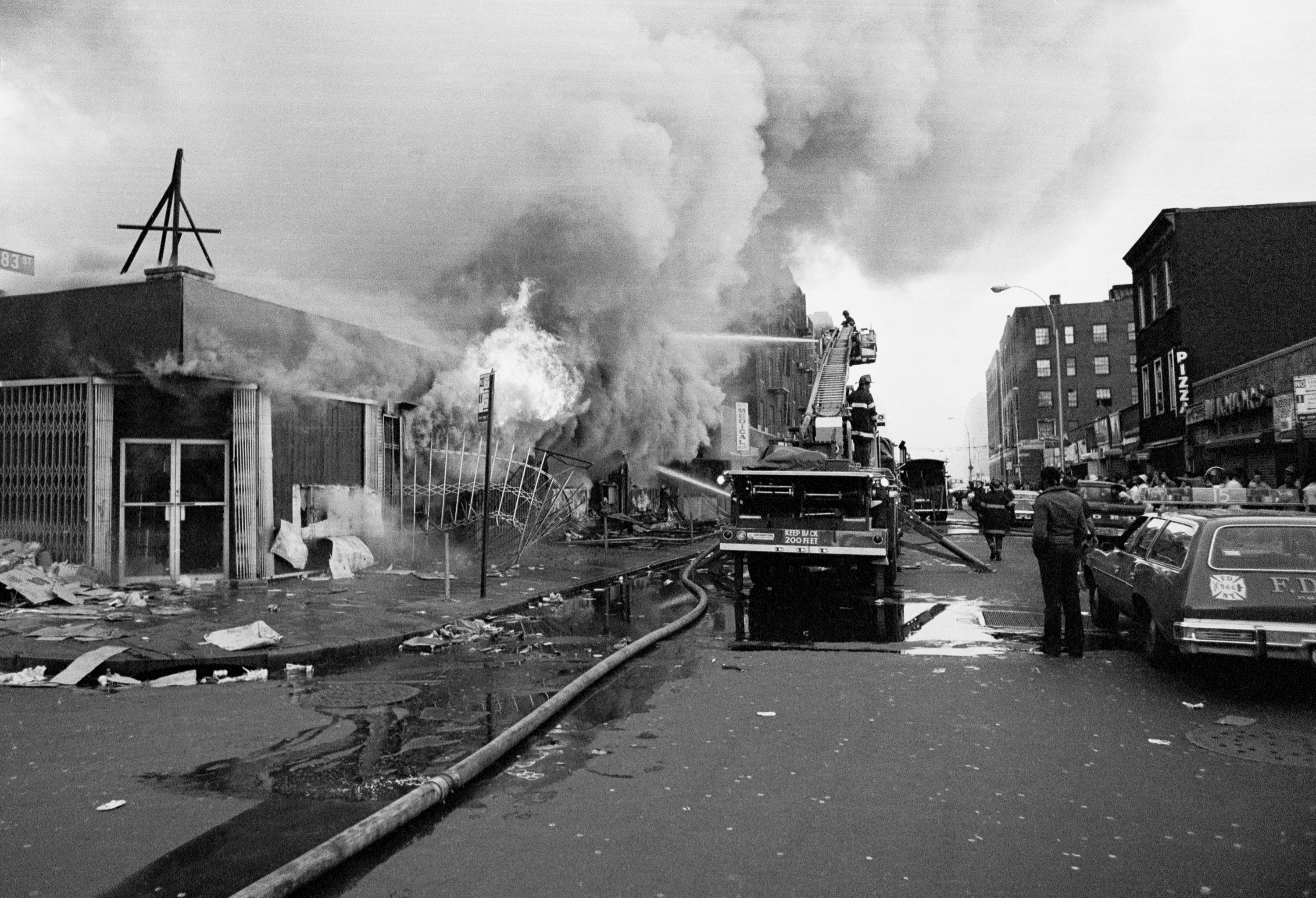 Firemen battle flames at a store in the Bronx borough of New York, one of many fires that broke out during the massive power failure that crippled the city for more than 24 hours, seen July 14, 1977. Firemen answered 1,500 alarms, 400 of which were actual fires. Forty of the fires were termed serious. (AP Photo)