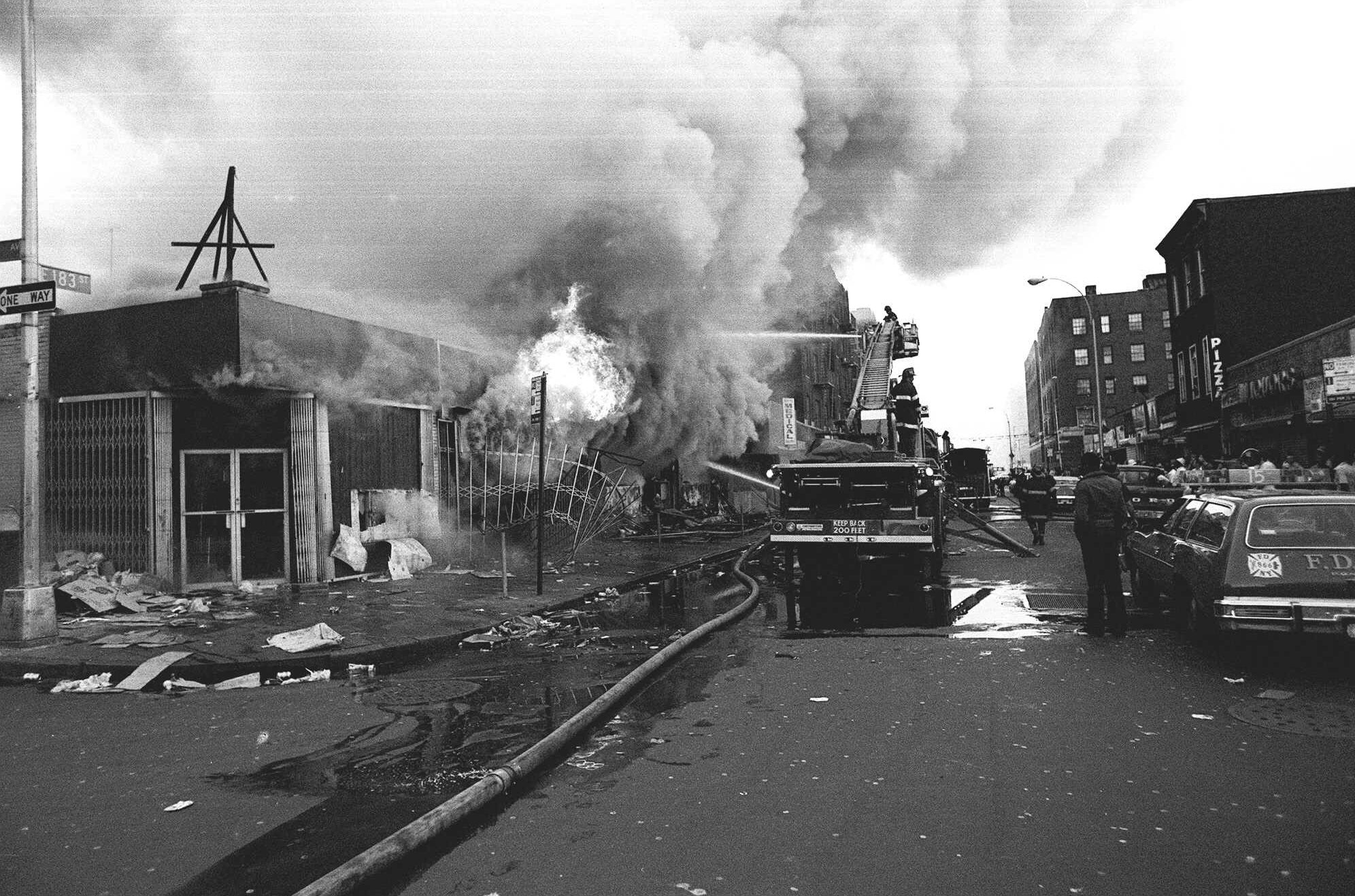 Firemen battle flames in a store an intersection in the borough of the Bronx on Thursday, July 14, 1977. This is one of many fires that broke out during the massive power failure that crippled New York City for more than 24 hours. (AP Photo)