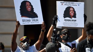 Signs are held up showing Breonna Taylor during a rally in her honor on the steps of the Kentucky State Capitol in Frankfort, Ky., Thursday, June 25, 2020.