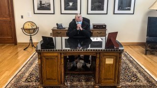 New Jersey Governor Phil Murphy observes a moment of silence for George Floyd, a Black Minneapolis man who died during an arrest by police, on a desk inscribed with Woodrow Wilson's name, June 4, 2020. Murphy said he has since found a replacement for the desk after people pointed out that Wilson defended slavery and practiced segregation.