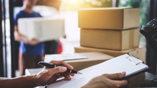 Moving boxes and man holding clipboard