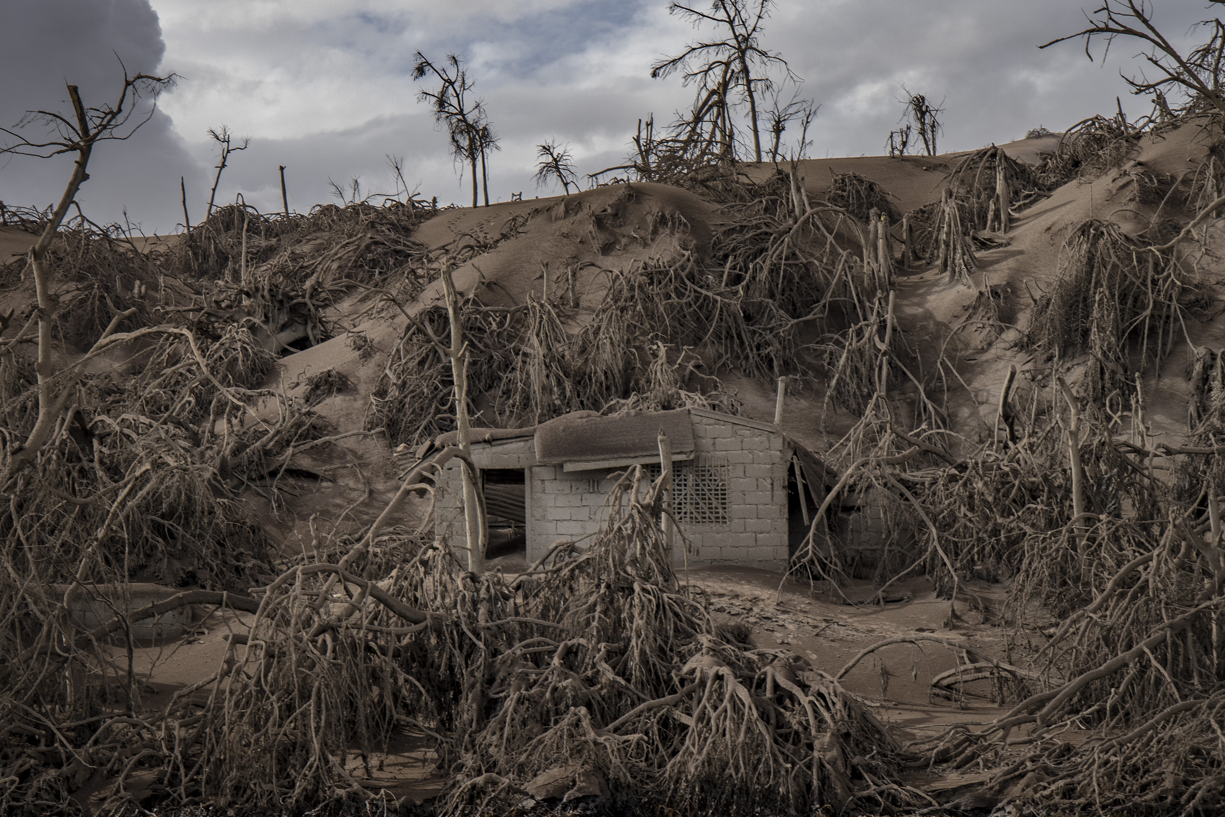 A house near Taal Volcano’s crater is buried in volcanic ash from the eruption on Jan. 14, 2020, in Taal Volcano Island,  Philippines. The Philippine Institute of of Volcanology and Seismology raised the alert level to four out of five, warning that a hazardous eruption could take place anytime, as authorities have evacuated tens of thousands of people from the area. An estimated $10 million worth of crops and livestock have been damaged by the on-going eruption, according to the country’s agriculture department. (