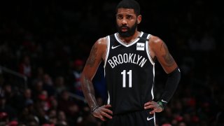 Kyrie Irving wearing a dark Brooklyn Nets uniform with his number 11 emblazoned on his shirt.