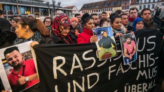 Relatives of Hanu shooting victims hold up photos