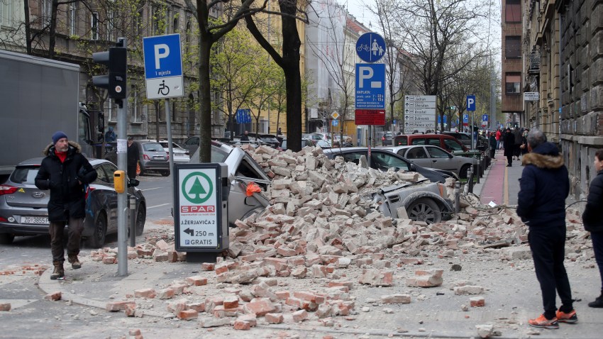 Fallen rubble smashes a parked car