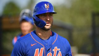Tim Tebow wearing a blue and orange Mets uniform and helmetGetty