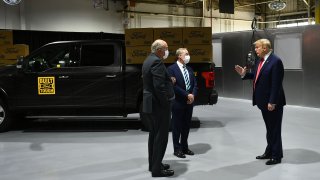 Ford Motor Company CEO Jim Hackett (L) and Executive Chairman of Ford William Clay Ford Jr. (C) speak with US President Donald Trump as they tour the Ford Rawsonville Plant in Ypsilanti, Michigan on May 21, 2020.
