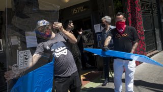 Viral Guard System workers wearing protective masks deliver plexiglass counter-top shields to a store in San Francisco, California, U.S., on Friday, May 29, 2020. Global plexiglass production increased substantially in March and April compared to February, according to ICIS, CNBC reported.