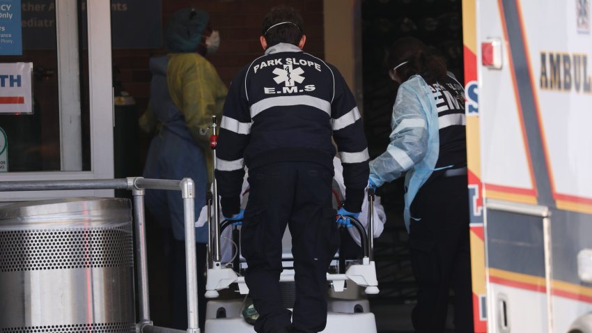 medical workers wheel patients inside