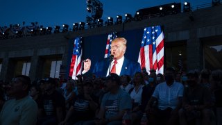 U.S. President Donald Trump is displayed on a screen as he speaks during an event at Mount Rushmore National Memorial in Keystone, South Dakota, U.S., on Friday, July 3, 2020. The early Independence Day celebration, which will feature a military flyover and the first fireworks in more than a decade, is expected to include about 7,500 ticketed guests who won't be required to wear masks or socially distance despite a spike in U.S. coronavirus cases.