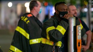 NEW YORK, NEW YORK – MAY 27: An FDNY firefighter wearing a mask leans on a pole in Times Square on May 27, 2020 in New York City. Government guidelines encourage wearing a mask in public with strong social distancing in effect as all 50 states in the USA have begun a gradual process to slowly reopen after weeks of stay-at-home measures to slow the spread of COVID-19. (Photo by Alexi Rosenfeld/Getty Images)