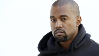 Kanye West poses before Christian Dior 2015-2016 fall/winter ready-to-wear collection fashion show in Paris.