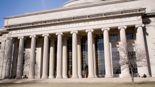 Students walk past the “Great Dome” atop Building 10 on the Massachusetts Institute of Technology campus in Cambridge, Massachusetts.