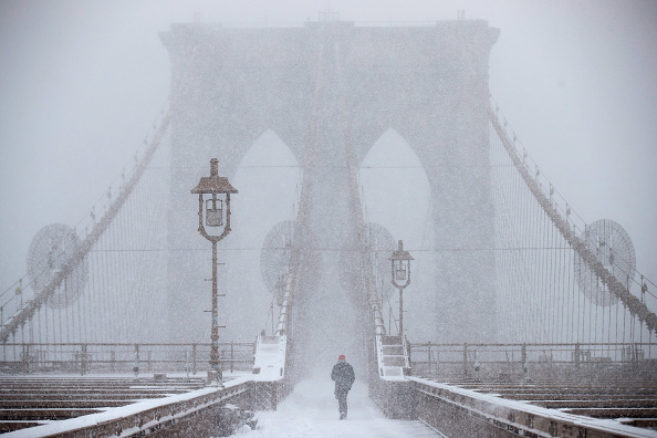 NEW YORK, NY - FEBRUARY 9: A man walks across the Brooklyn Bridge in the snow, February 9, 2017 in New York City. Following a day of 60 degree temperatures, New York City is expected to receive significant snowfall throughout the day on Thursday. (Photo by Drew Angerer/Getty Images)