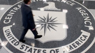 A man crosses the Central Intelligence Agency (CIA) seal in the lobby of CIA Headquarters in Langley, Virginia, on August 14, 2008.