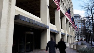 Pedestrians walk past the FBI headquarters in Washington, D.C.