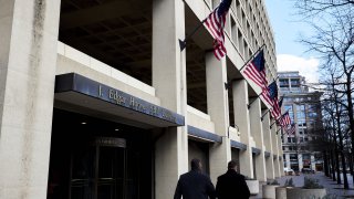 Pedestrians walk past the FBI headquarters in Washington, D.C.