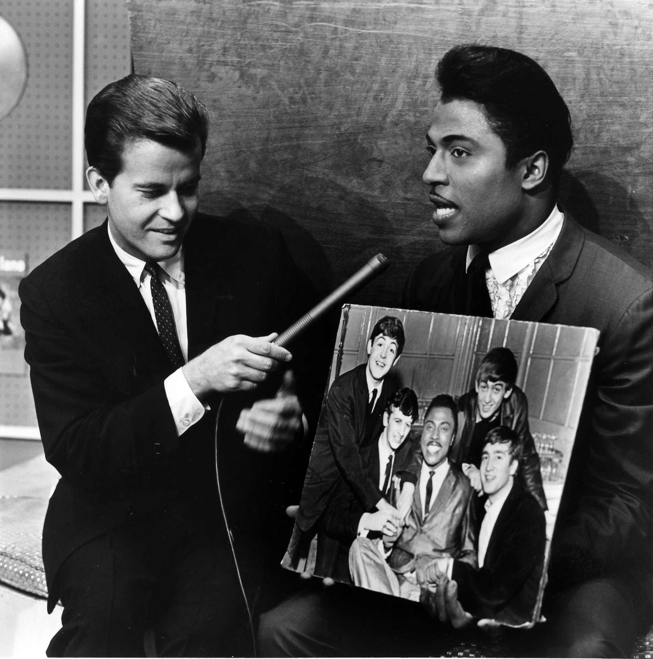 Dick Clark (left, with guest Little Richard holding a picture of the Beatles) hosted “American Bandstand,” the most popular dance show of all-time and the cornerstone of Walt Disney Television.